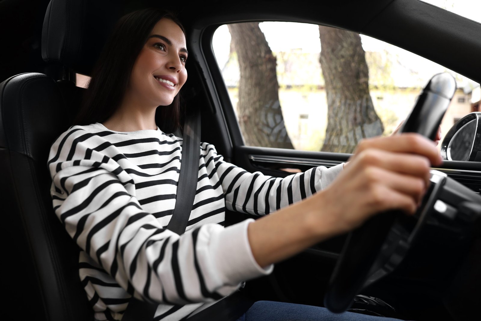 Woman with safety seat belt driving her modern car